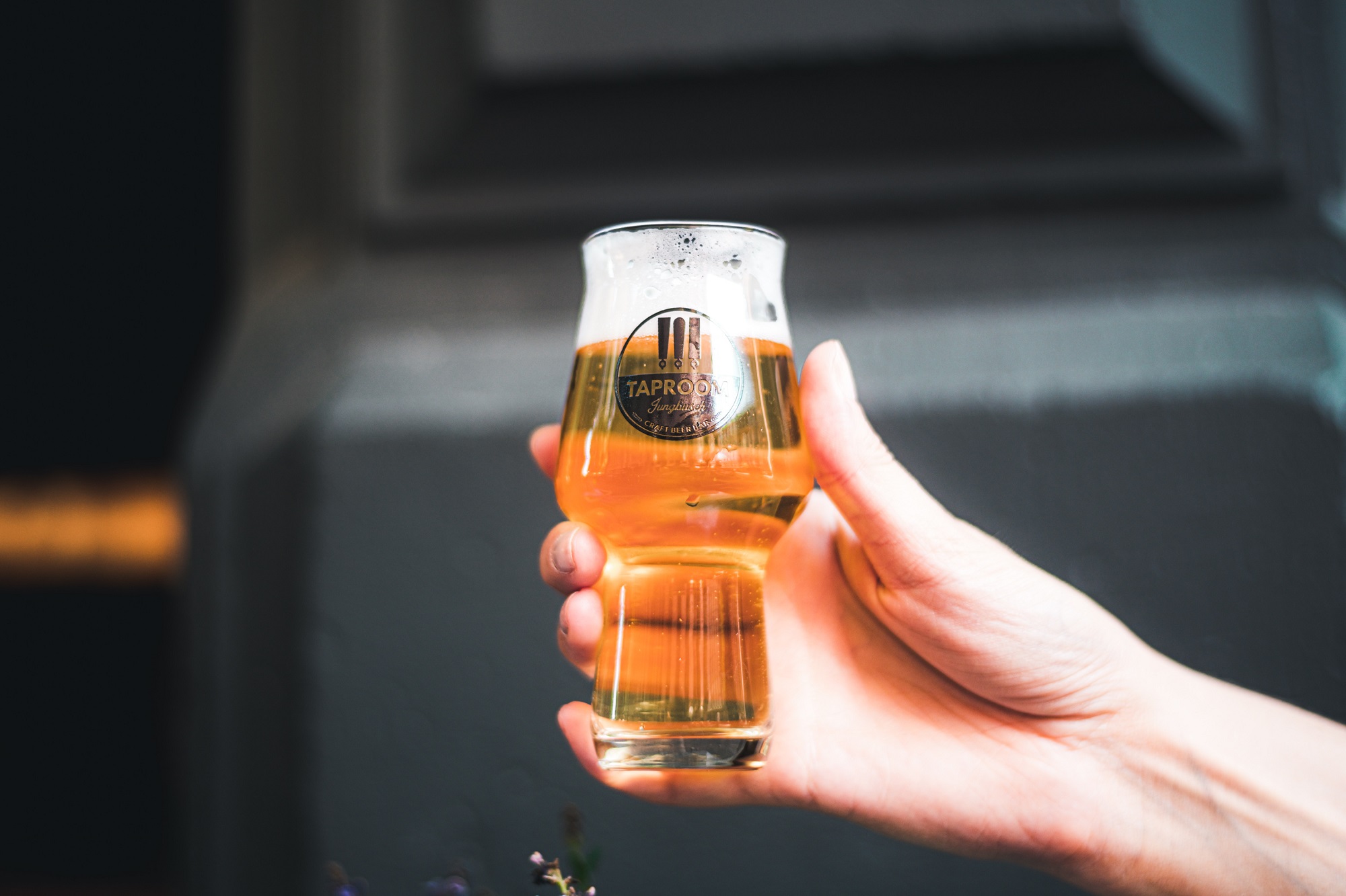 Glass of beer held in hand